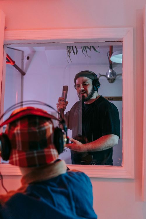 Free Bearded man singing into a microphone in a professional music studio. Stock Photo