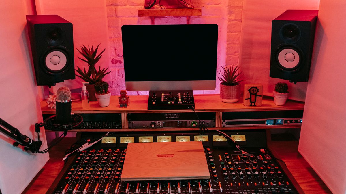 Professional music production studio with mixing console, speakers and computer