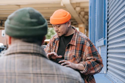 Free Urban scene featuring a man in orange beanie with plaid shirt, captured outdoors. Stock Photo