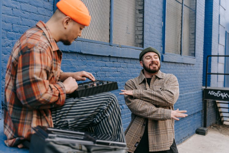 Men Sitting Outdoors With A Little Music Console And Rapping 