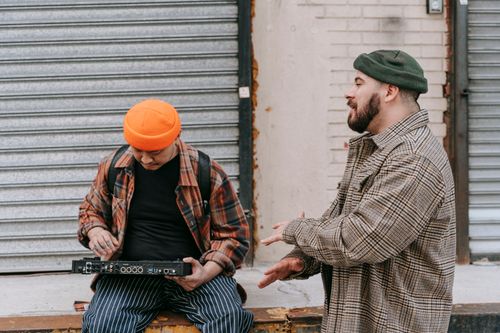 Free Two men mix music on a street, blending creativity and urban flair, captured in an outdoor setting. Stock Photo