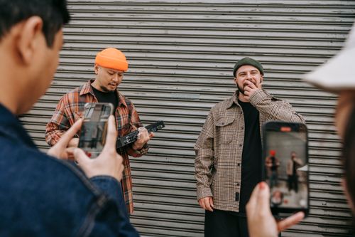 Free Street performance captured as people use smartphones to film musicians in urban setting. Stock Photo
