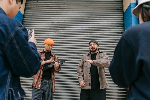 Free Street musicians play music in an urban setting with fans capturing the moment. Stock Photo