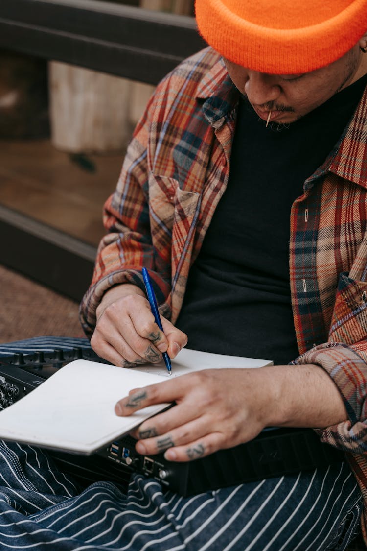 Man Writing Song In Notebook