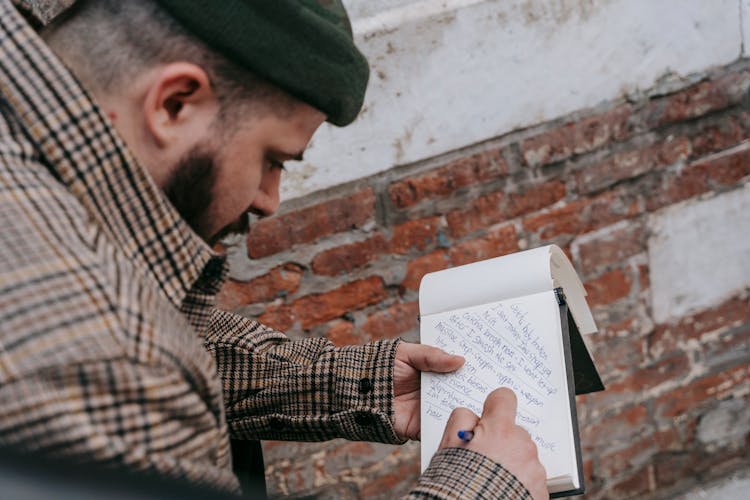 Man Writing Song Lyrics In Notebook