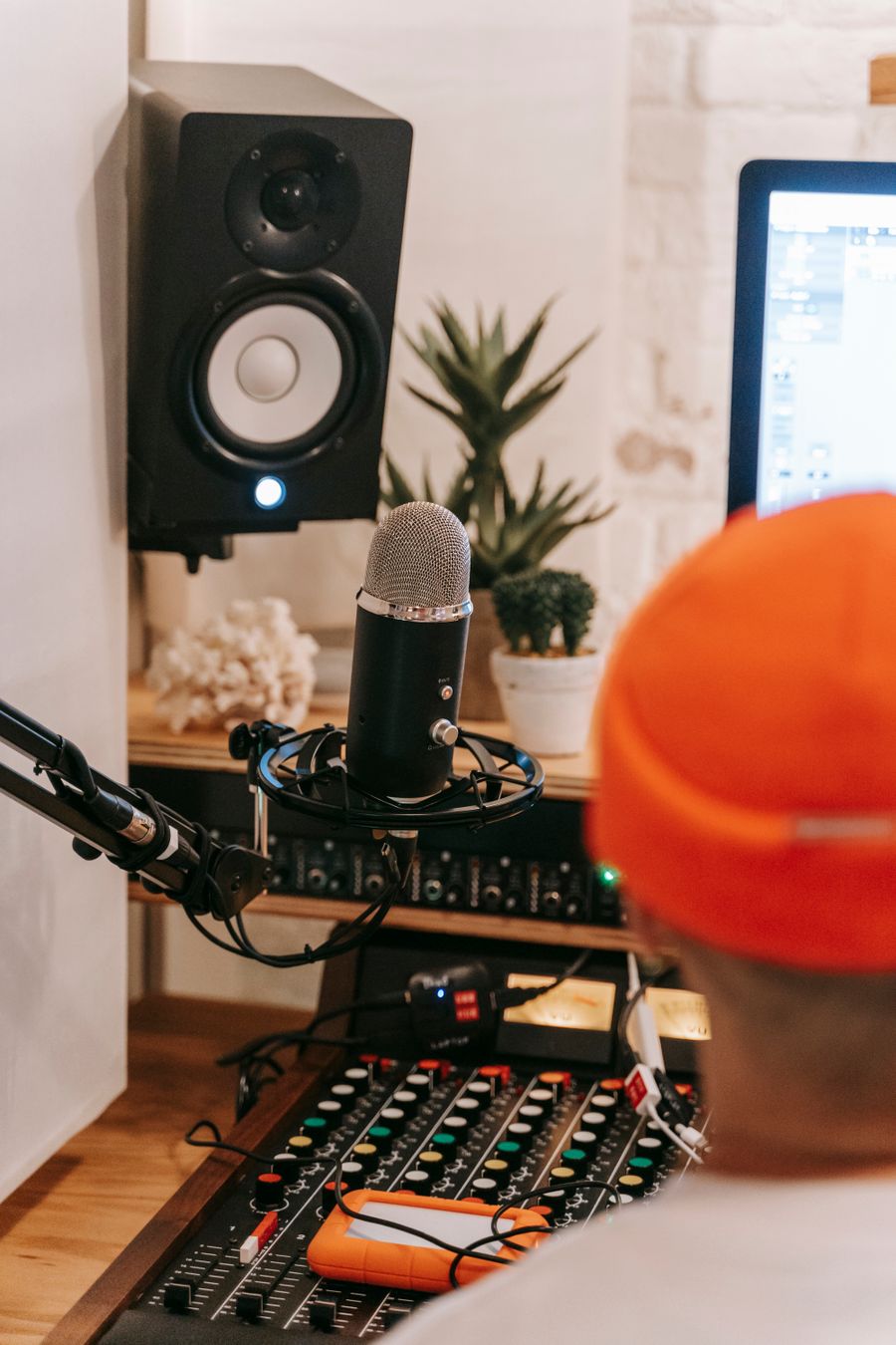 A condenser microphone and studio speaker in a recording space