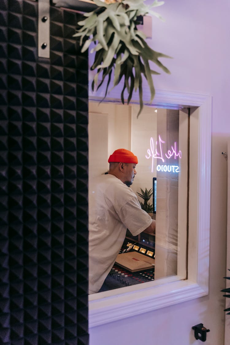 Man In White Shirt And Orange Beanie In Music Studio