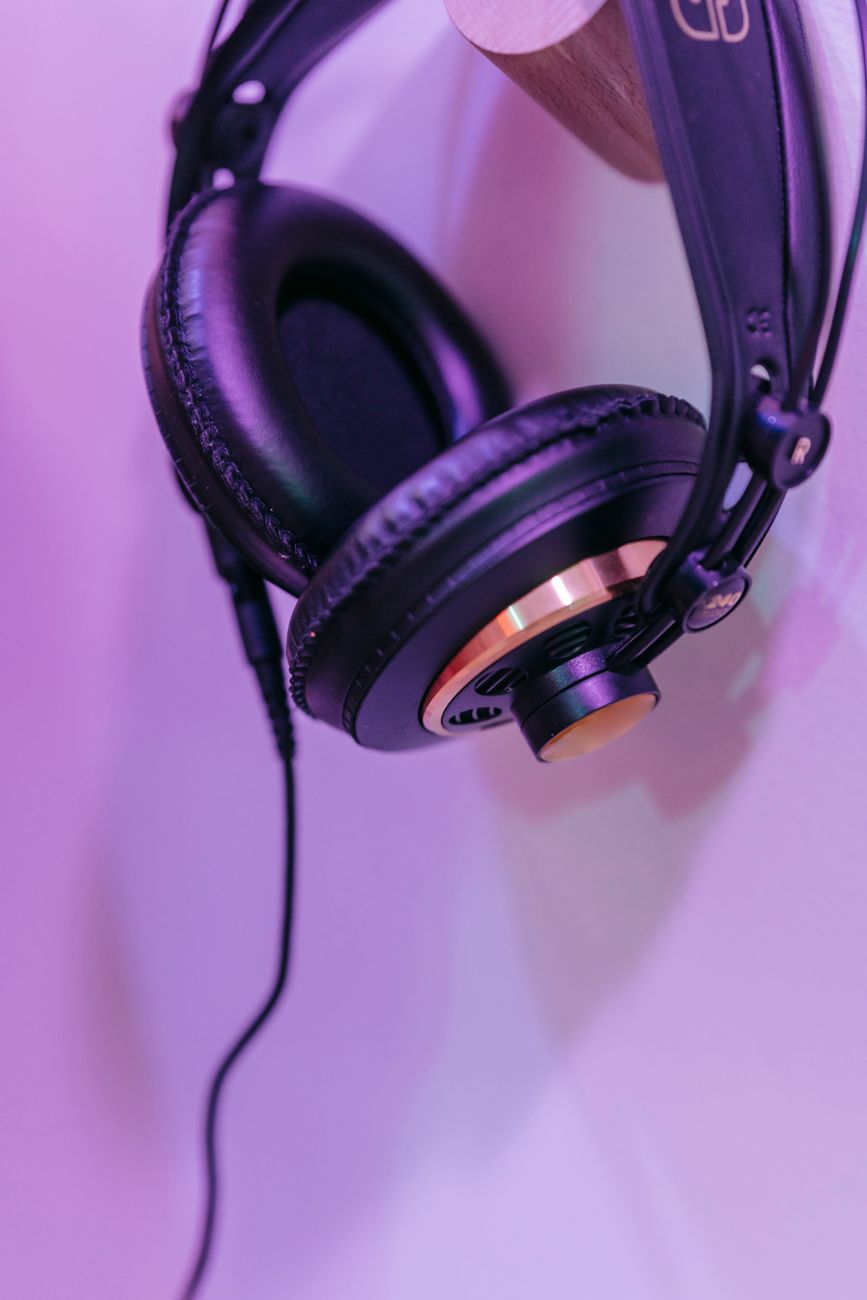 Headphones on a desk next to audio equipment
