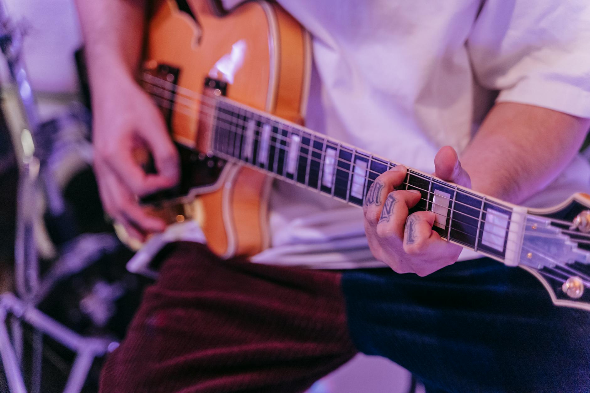 A musician strumming an electric guitar during a live performance, showcasing mu