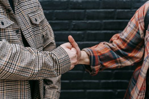 A close-up image of two people wearing checkered shirts engaging in a friendly handshake.