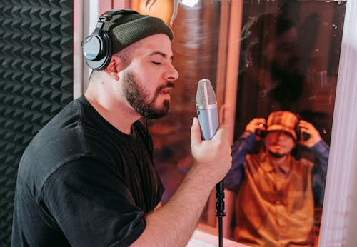 Man in Headphones Singing in Mic in Studio