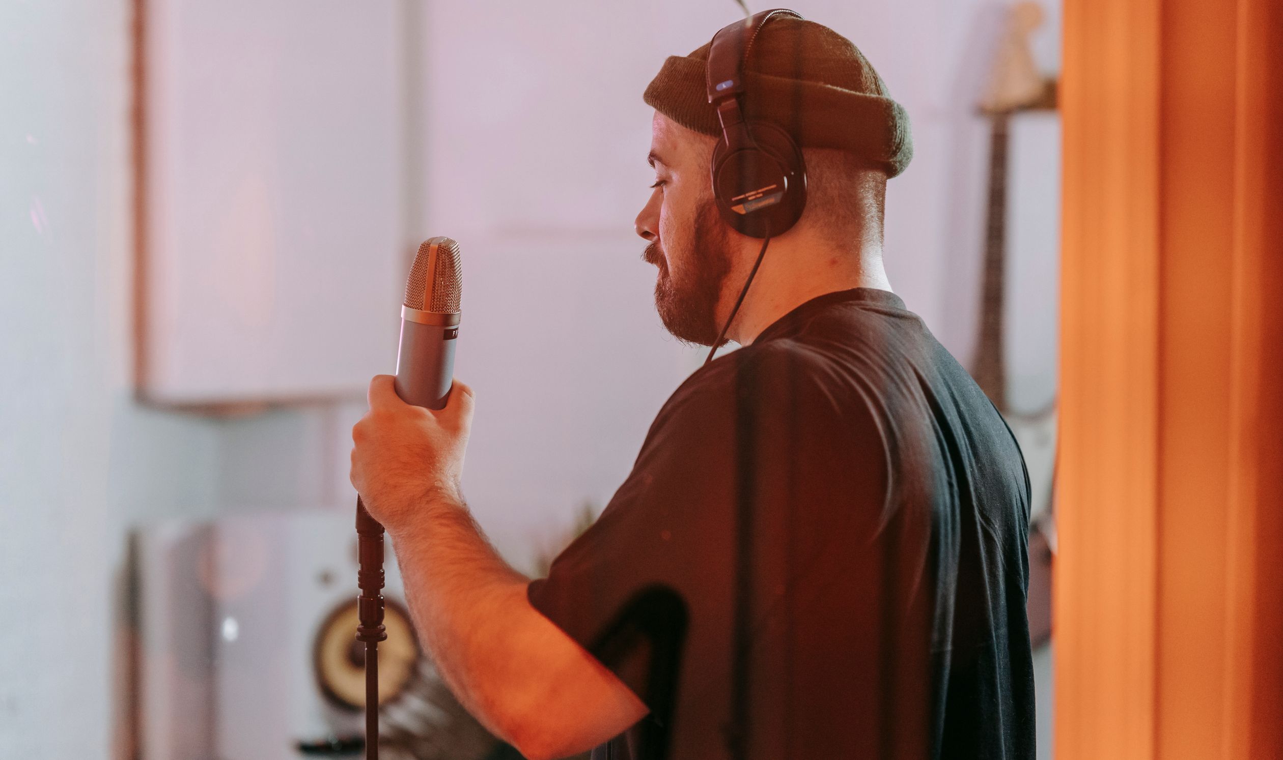 Singer Holding Microphone in Studio · Free Stock Photo