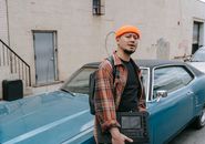 Man in Red and Black Plaid Button Up Shirt Standing Beside Blue Car