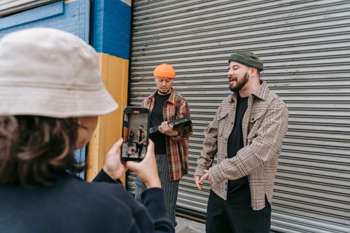 Free Musicians perform in an urban setting while being filmed by a mobile device. Stock Photo