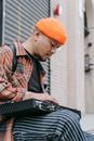 A Man in Orange Knit Cap Holding Electronic Device