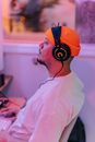 A Man in Orange Knit  Cap with Headphones