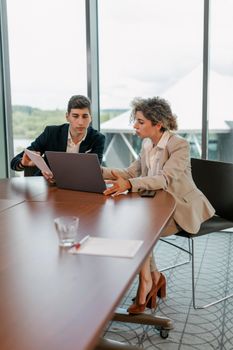 Two professionals collaborating in a modern office setting, focused on business solutions.
