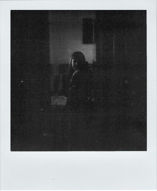 Free A dark and moody black and white portrait of an unrecognizable woman indoors. Stock Photo