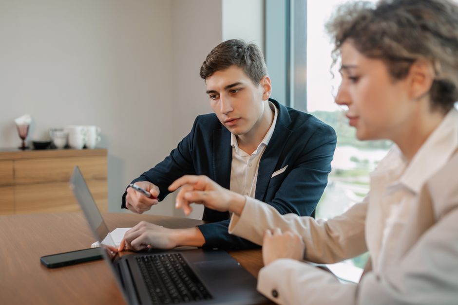 Profissionais discutindo trabalho em uma mesa de escritório moderna.