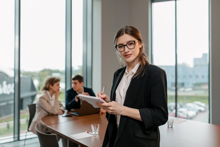 A Woman In Black Blazer Holding A Notebook