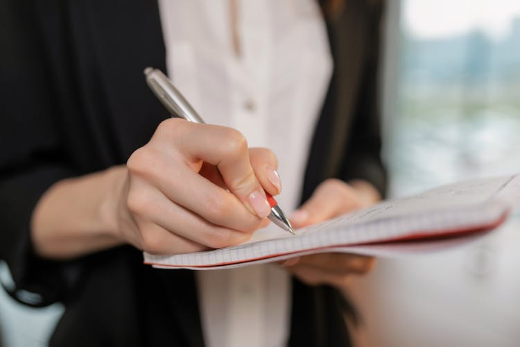 Person Holding Pen And Notebook