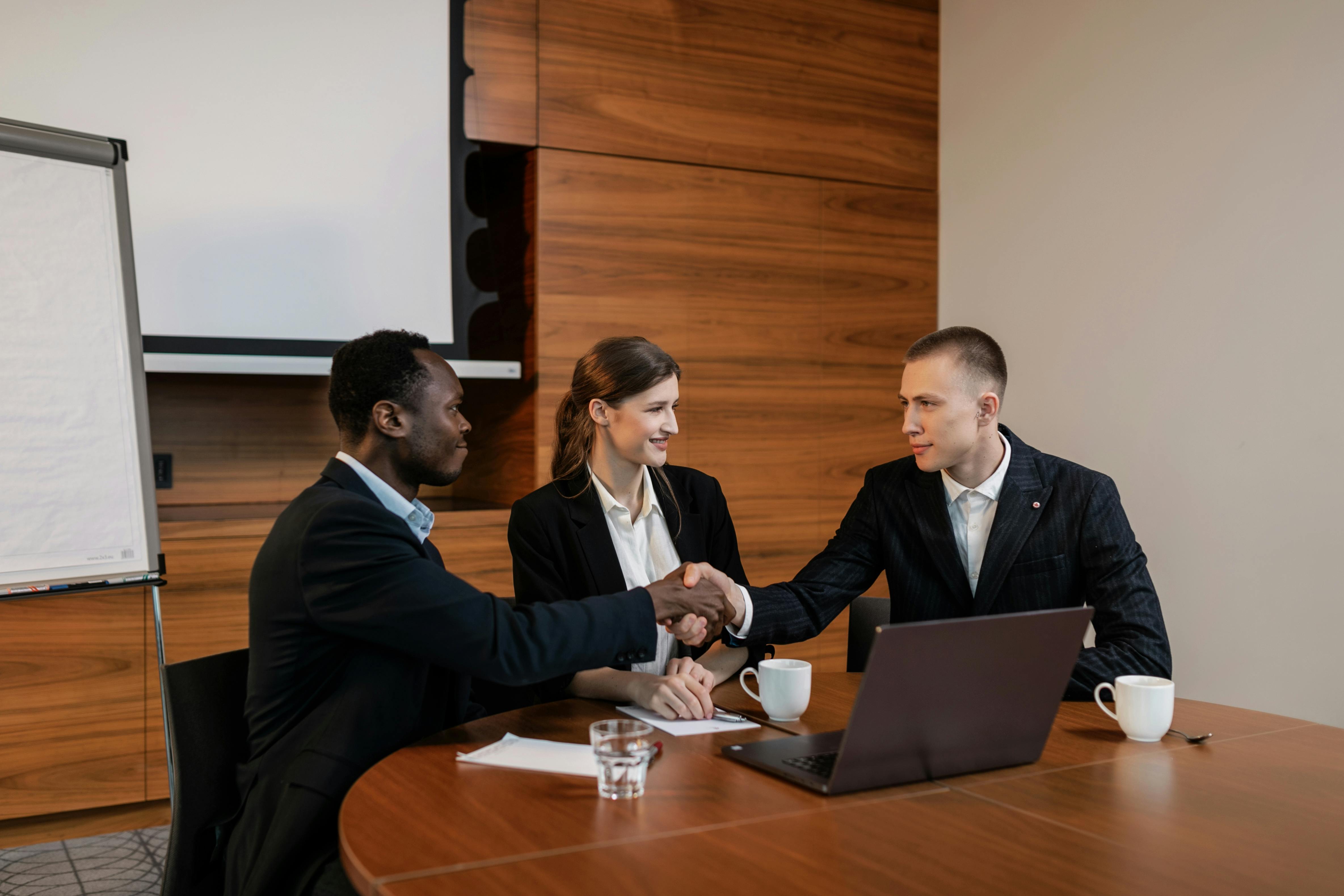 Free A Woman Sitting Between Two Men Having a Deal Stock Photo