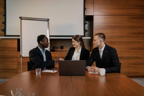 Free A diverse group of professionals engaged in a business meeting, collaborating and shaking hands in an office setting. Stock Photo