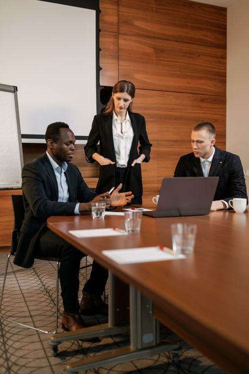 Free Three professionals discussing a project in a contemporary office setting. Stock Photo