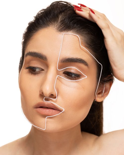 Free Close-up portrait of a woman with wire art on face, expressing conceptual beauty and creativity. Stock Photo