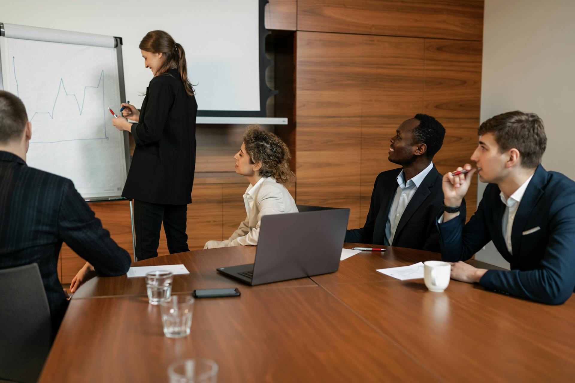 Man in Black Suit Sitting beside his Colleagues