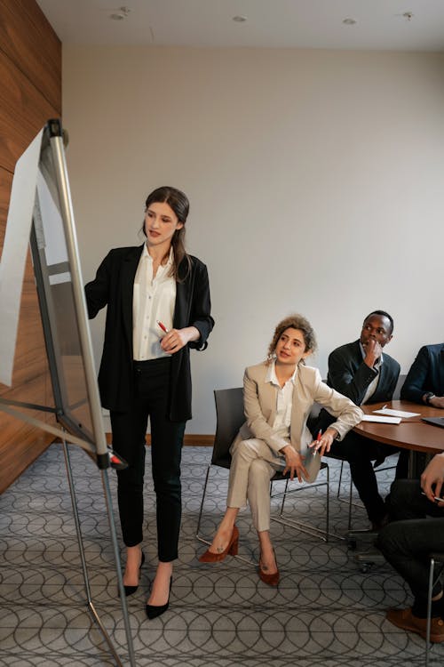 Free Woman in Black Suit Standing beside the White Board Stock Photo