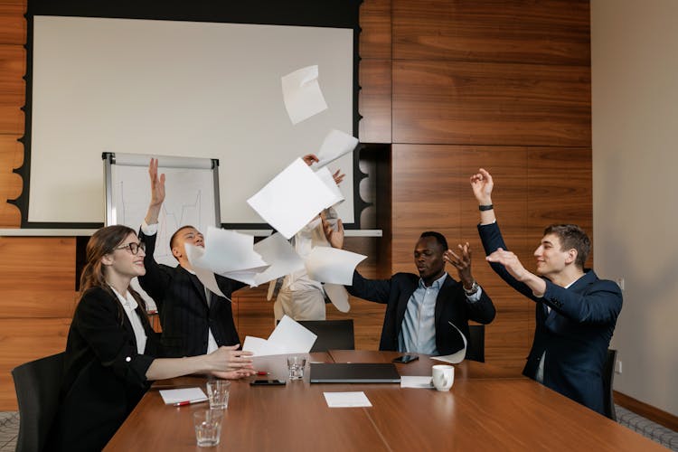 A Group Of A People Throwing The Papers