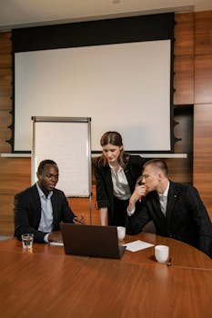 Multicultural team in a business meeting discussing plans at an office table.