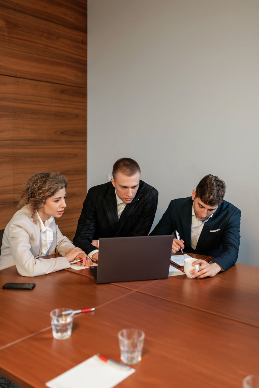 Réunion commerciale autour d’un ordinateur portable dans un bureau moderne