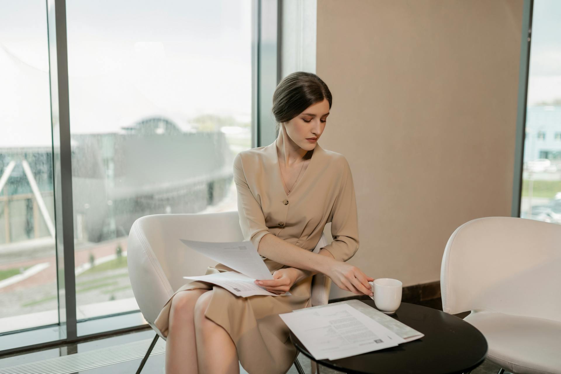 A Woman Having Coffee while Looking at a Document