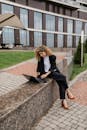 Woman in Black Blazer Using Laptop Outside Building