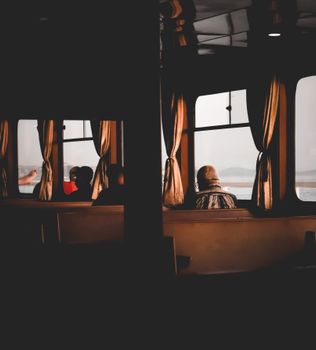 Passengers enjoying a peaceful ferry ride, gazing through the windows at scenic water views.