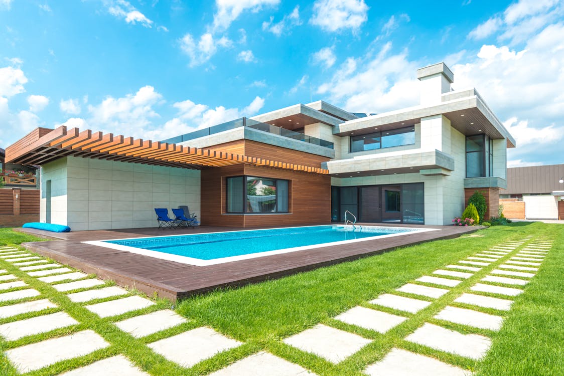 Free A Modern House with Swimming Pool Under the Blue Sky Stock Photo