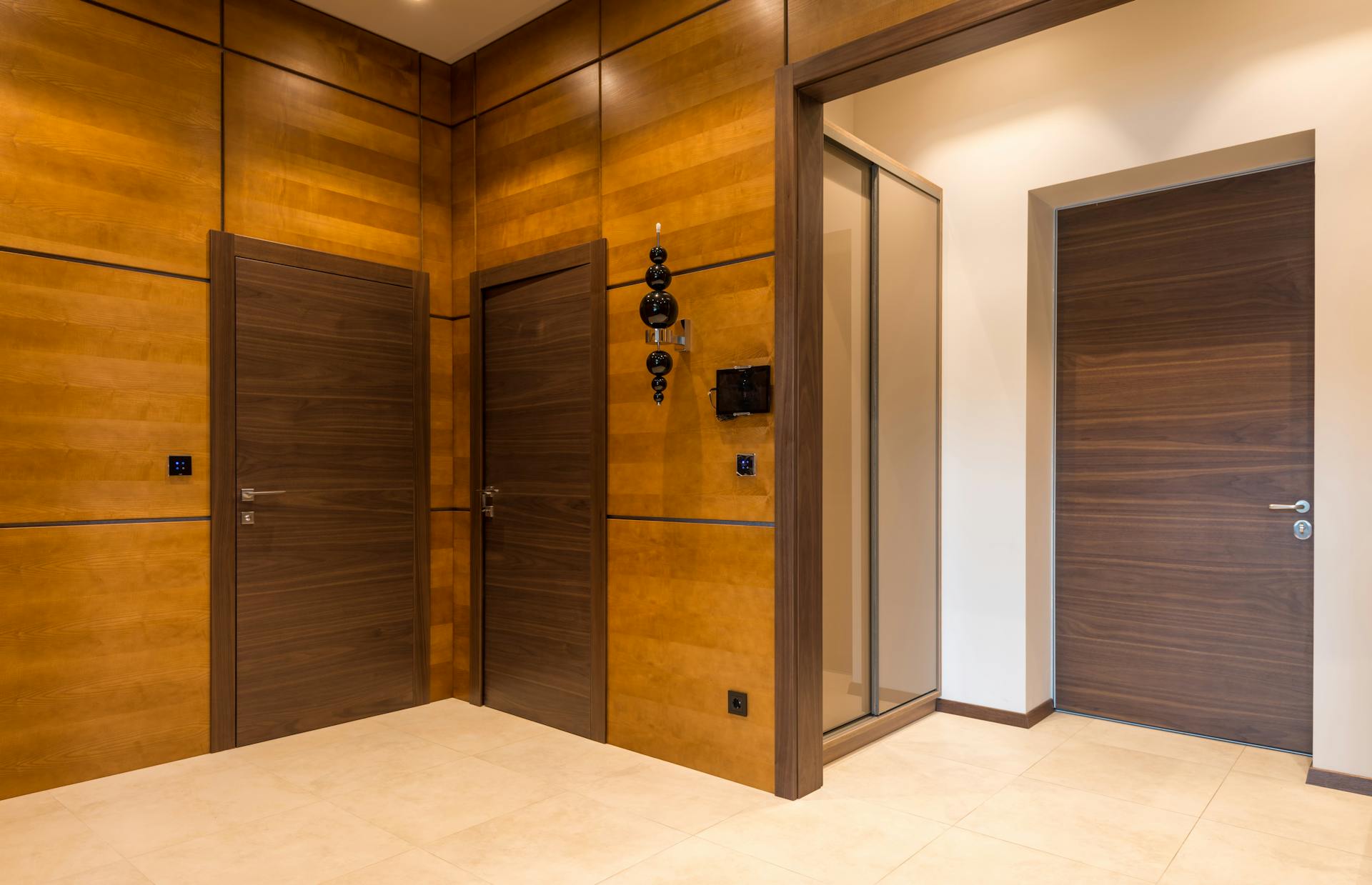 Contemporary room featuring sleek wooden doors and warm tones in a minimalist style.