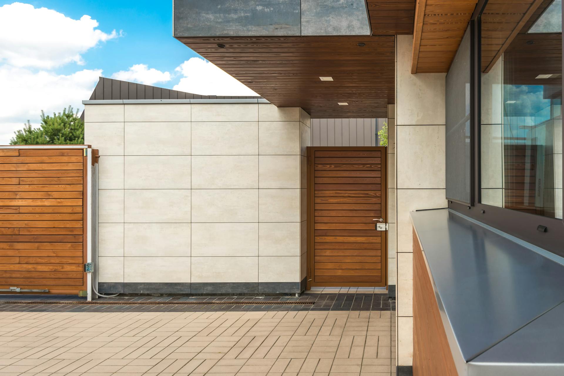 Contemporary home exterior showcasing minimalist design with wood features and a view of clear sky.