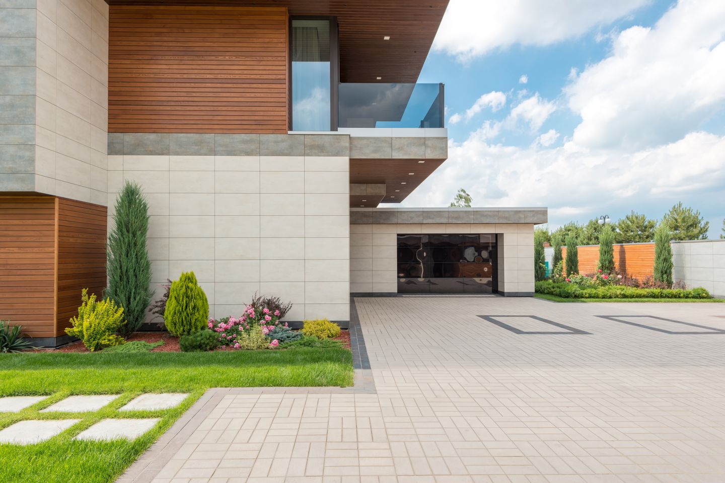 Spacious concrete driveway at a modern minimalist home in Hamilton, Ontario, with landscaped garden and clear blue sky. Spacious concrete driveway at a modern minimalist home in Hamilton, Ontario, with landscaped garden and clear blue sky.