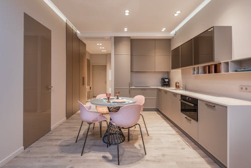 A Dining Table and Chairs Near the Kitchen Cabinets