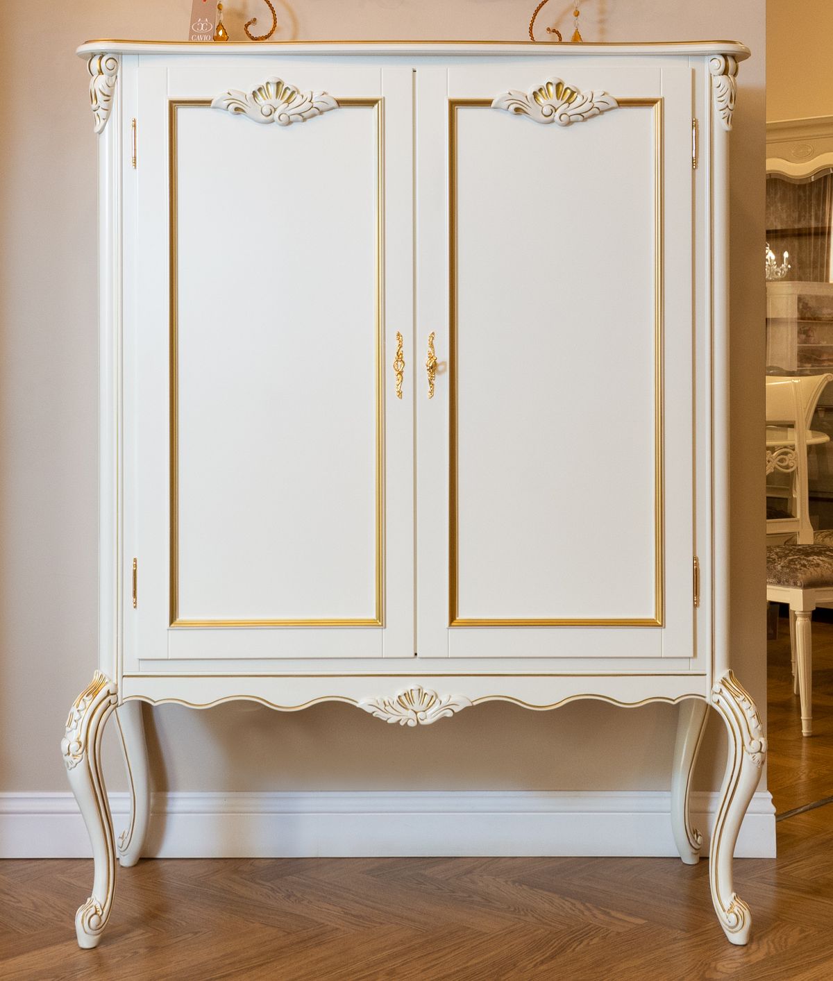 Classic vintage white armoire with ornate details in a cozy room
