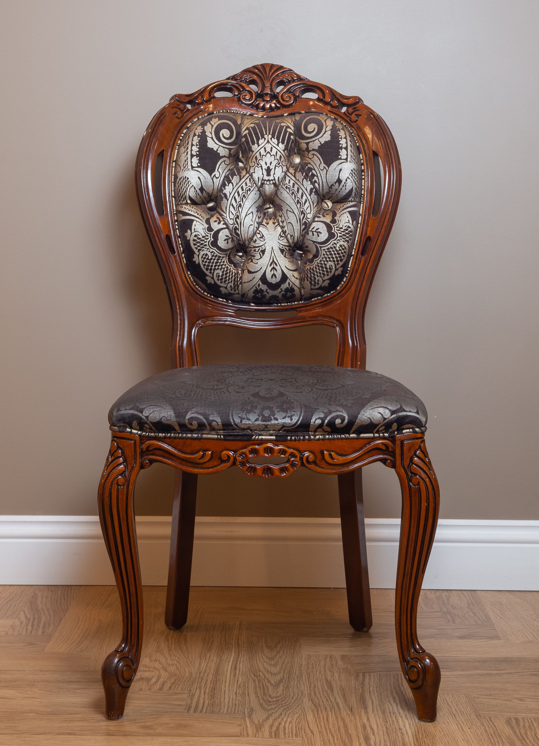Carved timber chair with a tufted patterned back and upholstered seat