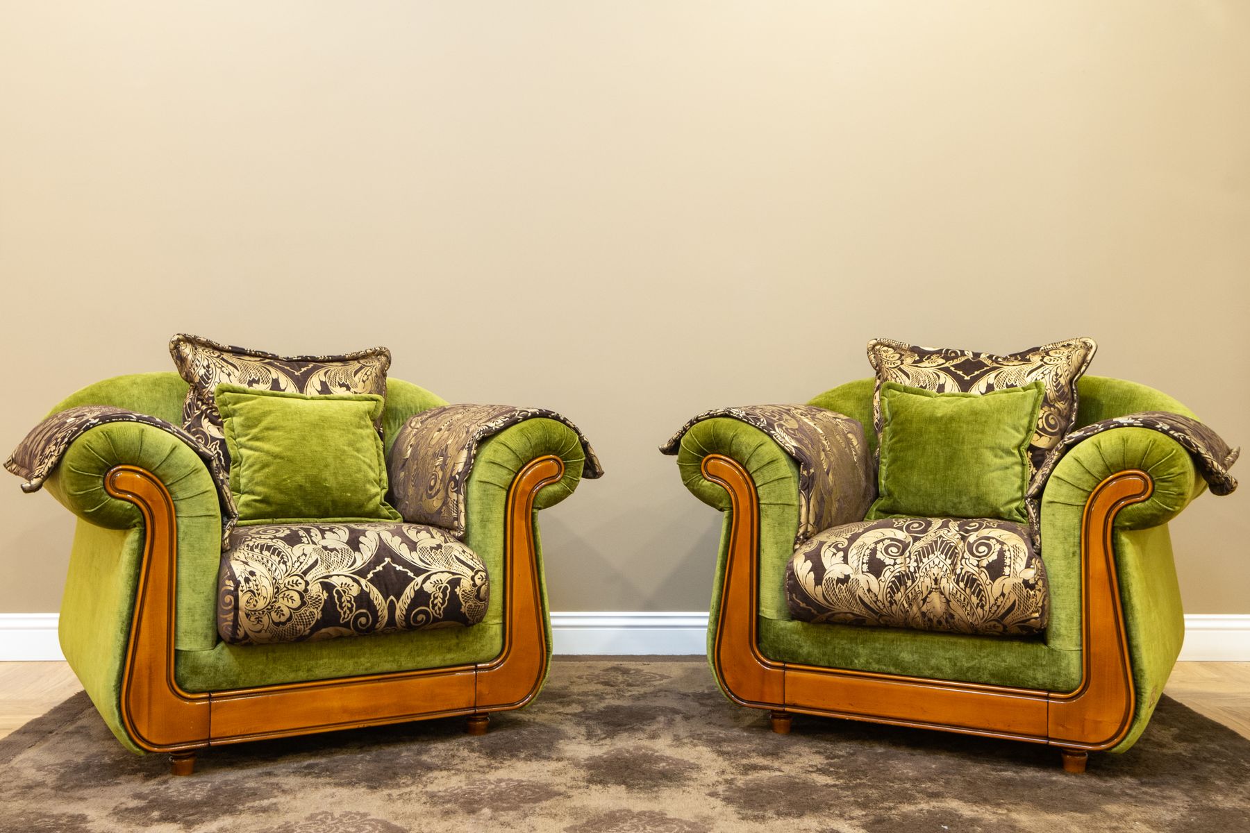 Two ornate green armchairs with patterned cushions