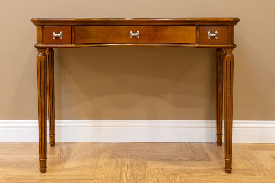 Elegant wooden console table featuring minimal design and three drawers with silver handles.