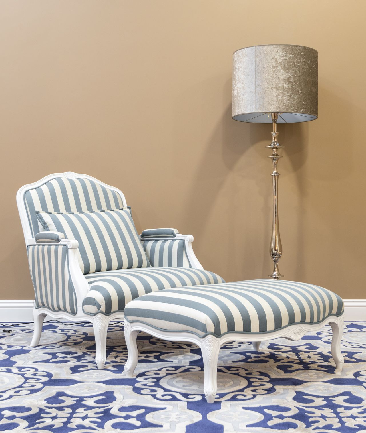 Striped armchair with matching ottoman and a tall silver floor lamp on a patterned rug