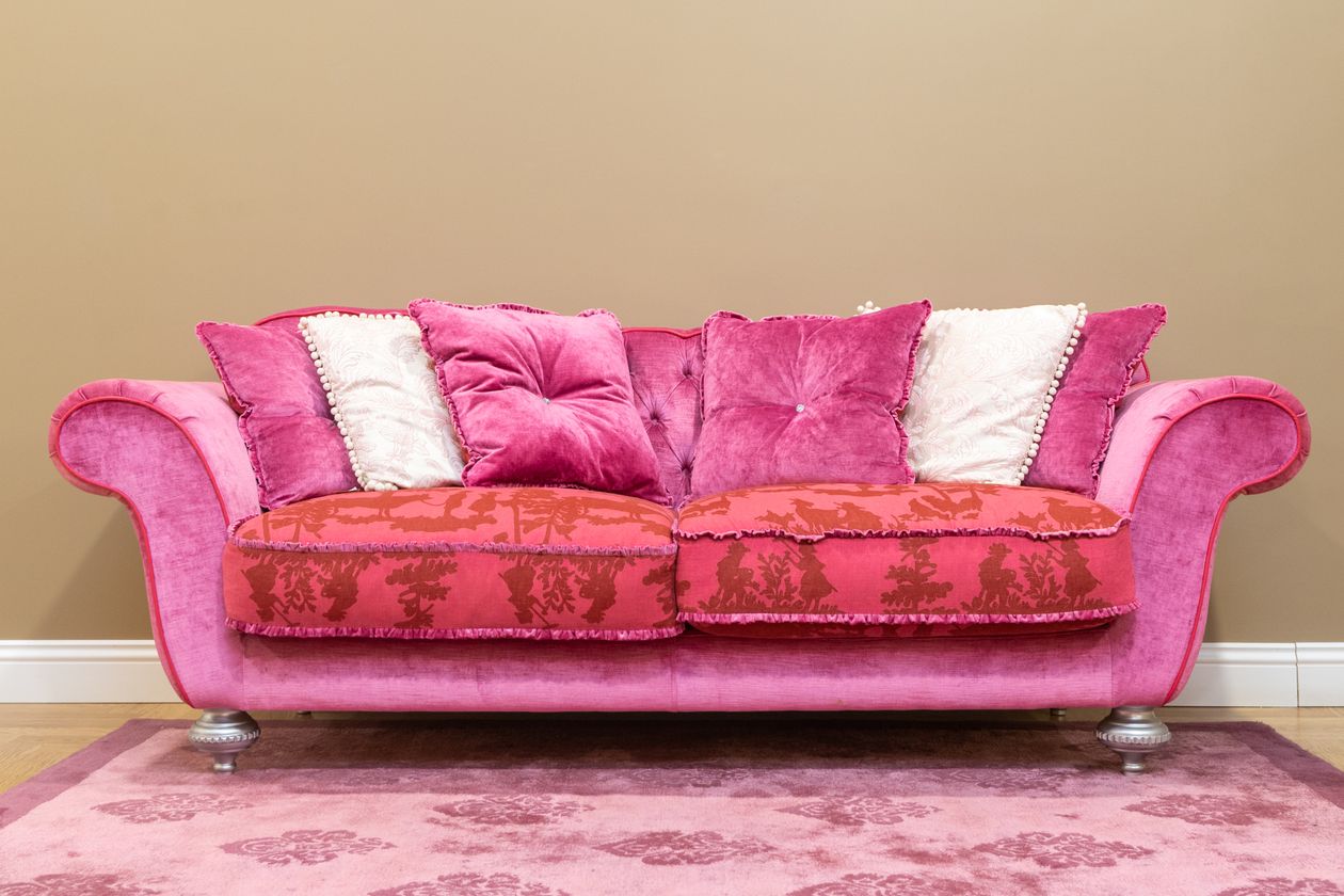 Bold pink velvet sofa with patterned throw pillows