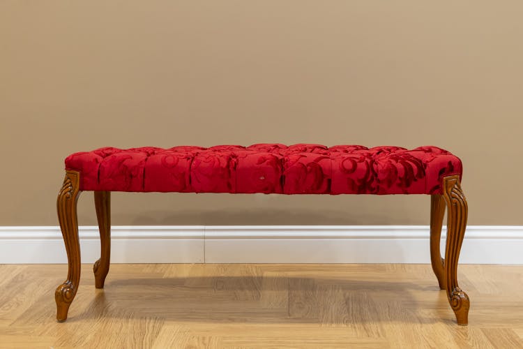 A Red Cushion Chair With Wooden Stand