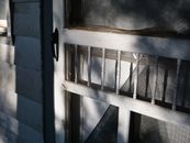 Close-up of rustic wooden door showing sunlight and texture.